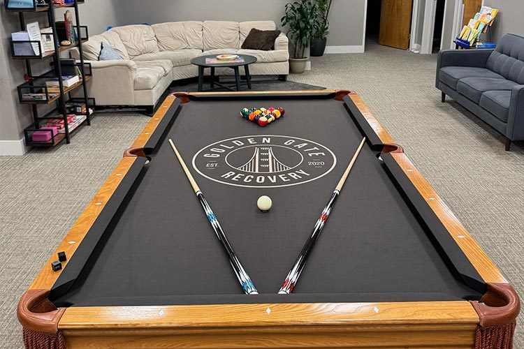 Golden Gate Recovery: Client recreation lounge featuring the custom Golden Gate Recovery pool table and sectional sofa