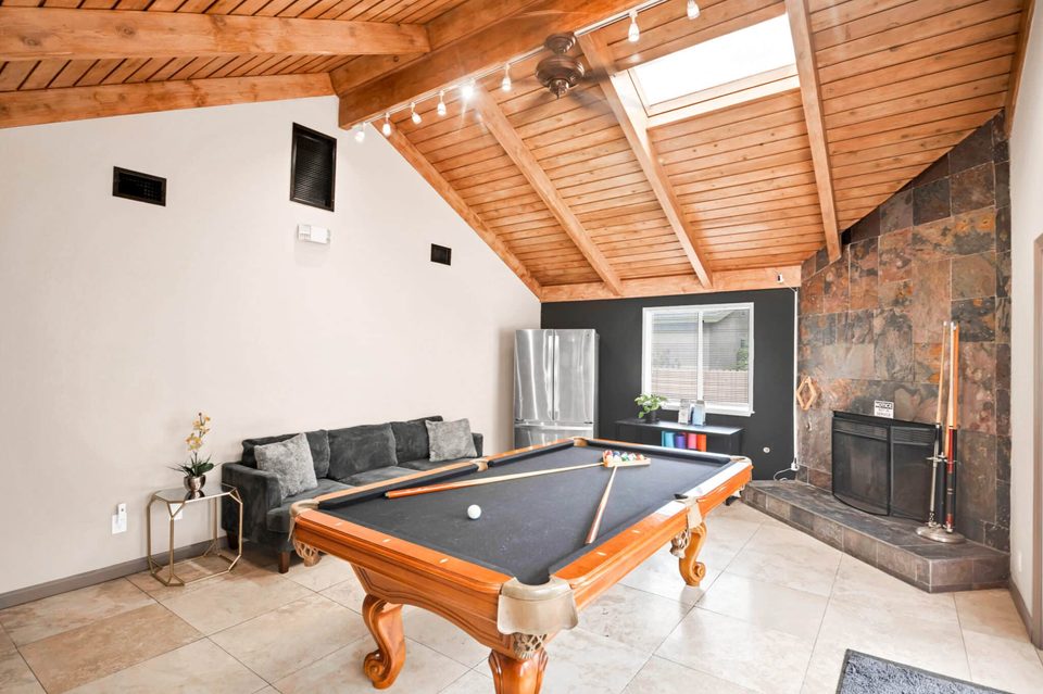 Northridge Addiction Treatment Center: Resident recreation lounge with pool table, vaulted wood ceiling, and stone fireplace
